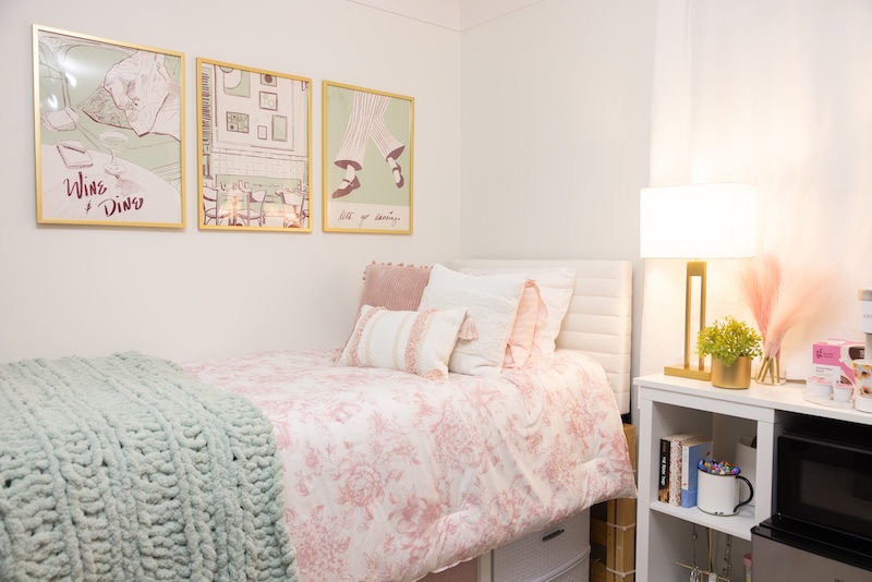 A sample dorm room in blush and sage along side of a fridge bridge