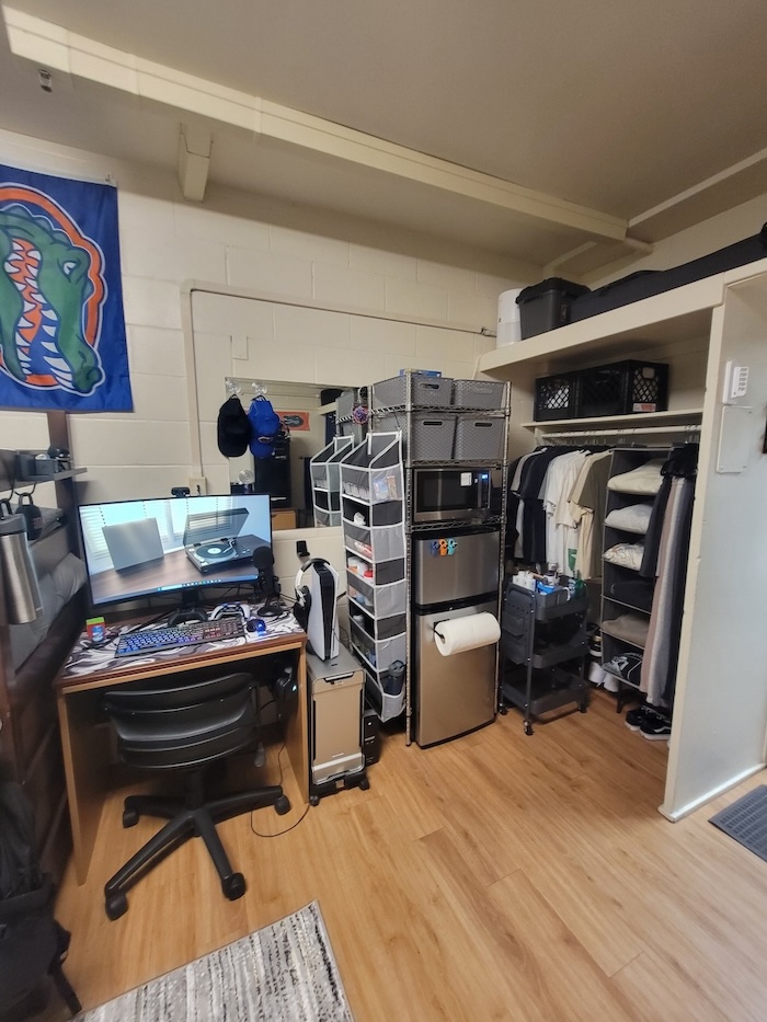 University of Florida boys dorm room with desk mini kitchen setup and open closet